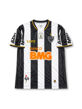 Atlético Mineiro 2013 home jersey featuring Ronaldinho #10, Lupo Sport black and white vertical striped soccer shirt with gold-trimmed V-neck, orange Banco BMG sponsor logo, CAM club crest, MRV sleeve branding, and RONALDINHO name and number 10 on the back, celebrating the club's 2013 Copa Libertadores winning season.