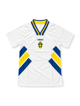 Sweden 1994 FIFA World Cup away jersey by adidas, featuring a white base with bold royal blue and yellow diagonal geometric stripes along the sides, a blue and yellow striped polo collar, adidas wordmark, and Swedish national team crest on the chest. Classic retro soccer jersey from the USA 1994 World Cup.