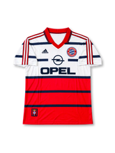 Bayern Munich 1998-00 away jersey featuring Lothar Matthaus #10, adidas soccer shirt with a white upper body, red lower section, navy horizontal stripes, red polo collar, red three-stripe shoulder detailing, black OPEL sponsor logo, Bayern Munich crest, and Bayern München lettering with Matthäus name and navy number 10 on the back.