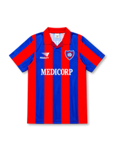 San Lorenzo de Almagro 1994 home jersey by Penalty, featuring bold red and navy vertical stripes, a red fold-over collar with fine striped detailing, diagonally color-blocked sleeves, white Penalty logo, MEDICORP sponsor across the chest, San Lorenzo club crest, and ASTORI branding on the back of this retro soccer jersey.