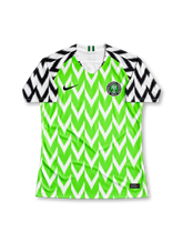 Nigeria 2018 FIFA World Cup home jersey by Nike, featuring a vibrant green body with bold white chevron zigzag patterns, contrasting white sleeves with black feather-inspired graphics, black Nike Swoosh, and circular Nigeria Football Federation crest. Iconic Super Eagles soccer jersey from the 2018 World Cup in Russia.