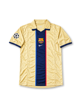 FC Barcelona 1999-00 labeled away jersey #10 by Nike, featuring a champagne gold body with a central navy vertical stripe, narrow blue and red accent stripes, fold-over collar, Nike branding, Barcelona club crest, UEFA Champions League sleeve patch, and navy number 10 on the back. Retro-style soccer jersey with unverified historical season attribution.