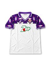 Fiorentina 1992-93 away jersey featuring Gabriel Batistuta #9, white Lotto soccer shirt with bold purple and black geometric graphics across the shoulders and sleeves, purple polo collar, green and red 7UP sponsor logo, Lotto branding, Fiorentina club crest, and BATISTUTA name with black number 9 on the back.