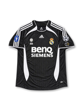 Real Madrid 2006-07 away jersey featuring Brazilian Ronaldo Nazario #9, black adidas soccer shirt with curved white side panels, white three-stripe shoulder detailing, white-trimmed crew neck, BenQ Siemens sponsor, Real Madrid club crest, FIFA Best Club of the 20th Century badge, UEFA Champions League sleeve patches, and RONALDO name with white number 9 on the back.