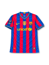 FC Barcelona 2009-10 home jersey featuring Zlatan Ibrahimovic #9, Nike blue and maroon vertically striped soccer shirt with yellow-trimmed V-neck collar and sleeve cuffs, yellow Nike Swoosh and UNICEF logo, Barcelona club crest, FIFA Club World Champions badge, UEFA Champions League sleeve patch, and IBRAHIMOVIĆ name with yellow number 9 on the back.