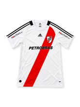 River Plate 2009-10 home jersey #10 by adidas, featuring a classic white soccer shirt with the iconic red diagonal sash, black adidas three-stripe shoulder detailing, white crew neck collar, black PETROBRAS sponsor logo, River Plate CARP crest, PokerStars.net sleeve branding, LUBRAX back sponsor, and black number 10 without player name.