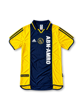 Front view of the 2000/01 Ajax centenary away soccer jersey in yellow and navy, featuring adidas three stripes, a navy polo collar, gold Ajax crest, and vertical white ABN AMRO sponsor.
