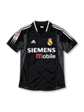 Front view of the black Real Madrid 2003/04 third soccer jersey featuring dark gray side panels, white adidas shoulder stripes, a crowned Real Madrid crest, Siemens Mobile sponsor, and La Liga LFP sleeve patch.