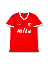 Front view of the Club Atlético Independiente 1984-85 red home football shirt associated with number 10 Ricardo Bochini, featuring a white V-neck collar and sleeve cuffs, white Topper logo, Independiente crest, and large white Mita sponsor graphic.