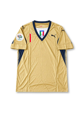 Gold Puma Italy 2006 World Cup goalkeeper away jersey associated with Gianluigi Buffon #1, featuring navy blue V-neck trim, Italian national team crest, Puma logos, and Germany 2006 World Cup sleeve patch.