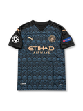 Manchester City 2020-21 dark navy and black PUMA away jersey featuring a geometric pattern, copper-colored club crest, PUMA logos, Etihad Airways sponsor and Sergio Aguero number 10.