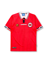 Norway 1998 World Cup home jersey, front view, red body with white and navy striped polo collar, Umbro wordmark, NFF crest, Norwegian flag emblem, NORGE lettering on sleeve cuffs