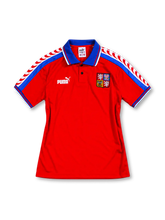 Czech Republic 1996 home jersey, front view, red with blue shoulder stripes and red and white wave motif, blue polo collar with two-button placket, white Puma logo, embroidered national crest, blue sleeve cuffs