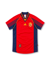 Spain 1998 home jersey, front view, red with navy side panels, navy V-neck with red and yellow trim, RFEF neck insert, yellow adidas logo, Spanish crest, navy shoulder stripes, RFEF hem patch