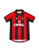 AC Milan 1998/00 home jersey featuring red and black vertical stripes, adidas logo, white Opel sponsor, and club crest, front view.