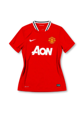 Manchester United 2011/12 red home jersey featuring Nike Swoosh, white Aon sponsor, club crest, and black-and-white striped collar, front view.