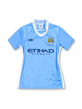 Manchester City 2011/12 sky-blue home jersey with white V-neck collar, Umbro logo, Etihad Airways sponsor, and club crest, front view.