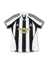 Newcastle United 2005/06 black-and-white striped home jersey featuring adidas shoulder stripes, Northern Rock sponsor, and club crest, front view.