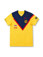 Club América 2006 yellow home jersey featuring a navy-and-red chest chevron, red Nike Swoosh, club crest, Bimbo and Coca-Cola logos, front view.