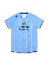 Manchester City 2007/08 sky-blue home jersey with white pinstripes, Le Coq Sportif logo, central club crest and Thomas Cook.com sponsor.