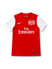 Arsenal 2011/12 red home jersey with white sleeves, white Nike Swoosh, Fly Emirates sponsor, and special 125th-anniversary laurel crest.