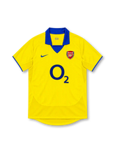 Arsenal 2003/04 yellow away jersey with royal-blue polo collar, blue Nike Swoosh, club crest, navy O2 sponsor and blue sleeve trim.