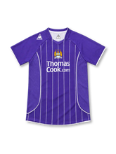 Manchester City 2007/08 purple away jersey with white vertical pinstripes, Le Coq Sportif logo, three-star club crest, and Thomas Cook.com sponsor.
