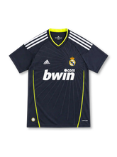 Real Madrid 2010/11 dark navy away jersey with white adidas shoulder stripes, fluorescent yellow trim, radiating chest graphic, crowned crest and bwin.com sponsor.