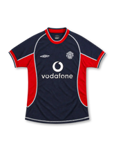 Manchester United 2000/01 navy third jersey with red side panels, white Umbro logo, monochrome club crest, white Vodafone sponsor and contrasting seams.