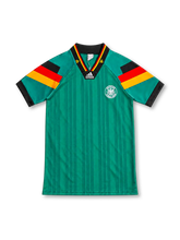 Germany 1992 green away jersey with tonal vertical stripes, black-red-gold sleeve bands, black V-neck collar, white adidas Equipment logo and circular DFB eagle crest.