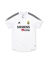 Real Madrid 2004/05 white home jersey with black adidas three-stripe shoulders, white fold-down collar, club crest, Siemens mobile sponsor and ClimaCool branding.