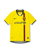 Barcelona 2008/10 yellow away jersey with navy-and-red vertical stripe, navy Nike Swoosh, FCB crest, UNICEF chest sponsor, navy crew-neck collar and NikeFIT branding.