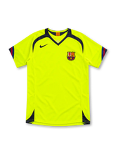 Barcelona 2005/06 neon yellow away jersey by Nike with navy V-neck and shoulder panels, red-and-blue sleeve trim, navy Swoosh, FCB crest and sponsor-free front.