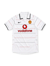 Manchester United white retro jersey with fine red-and-black horizontal pinstripes, white polo collar with black edging, black Nike Swoosh, club crest and red Vodafone sponsor.