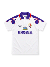 Fiorentina 1995/96 white Reebok away jersey with a purple polo collar, red-and-white trim, oversized purple lily shoulder graphics, Fiorentina diamond crest and purple Sammontana sponsor lettering.