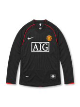 Manchester United 2007/08 black Nike away long sleeve jersey featuring subtle vertical pinstripes, red shoulder piping and sleeve cuff accents, white Nike Swoosh, full-color club crest, white AIG sponsor and Red Devils hem patch.