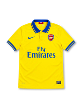 Arsenal 2013/14 yellow Nike away jersey featuring a blue polo collar with yellow trim, blue sleeve cuffs, blue Nike Swoosh, Arsenal club crest, blue Fly Emirates sponsor, Dri-FIT branding and Authentic hem label.
