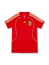 Spain 2008 adidas home jersey in bright red with gold shoulder stripes, gold curved piping, red crew-neck collar, yellow adidas logo, Spanish national crest, and patterned side panels.