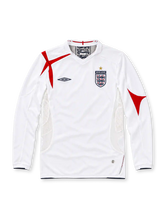 England 2006 Umbro home long sleeve jersey in white with red St George's Cross-inspired shoulder and sleeve graphics, white collar, black Umbro logo, Three Lions crest with gold star, white mesh side panels, and black trim.