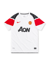 Manchester United 2010/11 white Nike away jersey with black and red geometric shoulder panels, white crew neck, red Nike Swoosh, club crest, black Aon sponsor, Dri-FIT branding, and Authentic-style hem label.