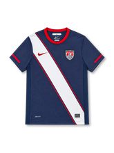 USA 2010 Nike away jersey in navy blue with a broad white diagonal sash outlined in red, red crew-neck collar and sleeve accents, red Nike Swoosh, United States Soccer crest, Dri-FIT branding, and Authentic-style hem label.