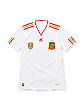 Spain 2011/12 white adidas away jersey with red and yellow shoulder stripes, red-trimmed V-neck collar, gold FIFA World Champions 2010 badge, Spain crest with gold star, red adidas logo, and CLIMACOOL detailing.
