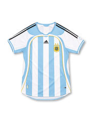 Argentina 2006 adidas home jersey with sky-blue and white vertical stripes, black adidas shoulder stripes, white sleeves, curved sky-blue panels, gold piping, central adidas logo, AFA crest with two gold stars, and CLIMACOOL detailing.