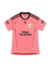 Galatasaray 2010/11 pink third jersey with black adidas stripes, three-star crest and Türk Telekom sponsor