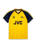 Arsenal 1988-90 away jersey, front view, yellow body with navy raglan sleeves, yellow V-neck collar with navy and red trim, adidas trefoil logo, club cannon crest, JVC sponsor logo, navy sleeve cuffs