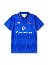 Chelsea 1989-91 home jersey, front view, royal blue body with diagonal jacquard texture, striped point collar, two-button placket, Umbro diamond logo, club lion crest, Commodore sponsor logo