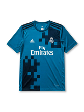 Real Madrid 2017-18 third jersey, front view, teal body with pixelated navy gradient pattern, adidas three-stripe shoulder detailing, crew neck collar, adidas logo, club crest, Fly Emirates sponsor logo, Climacool label