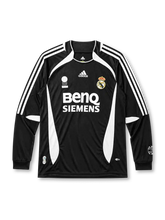 Real Madrid 2006-07 long sleeve third jersey, front view, black body with white side panels, adidas three-stripe long sleeve detailing, FIFA Fair Play emblem, adidas logo, club crest, BenQ Siemens sponsor logo, ribbed cuffs