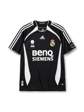 Real Madrid 2006-07 third jersey, front view, black body with white side panels, adidas three-stripe shoulder detailing, FIFA Best Club of the Century emblem, adidas logo, club crest, BenQ Siemens sponsor logo, sleeve patch