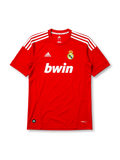 Real Madrid 2011-12 third jersey, front view, red body, white adidas three-stripe shoulder detailing, crew neck collar, adidas logo, club crest, bwin sponsor logo, Climacool label